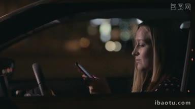 特写迷人的金发女人坐在车里，在她的手机背景城市街道上发短信
